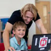 Teacher supporting coding camp student